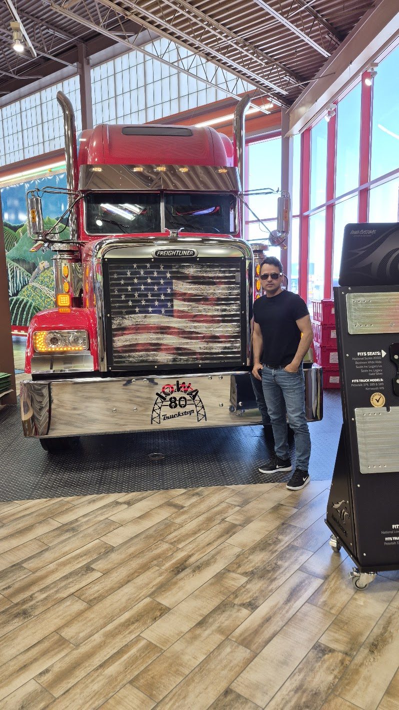 David junto al frente de un Freightliner rojo