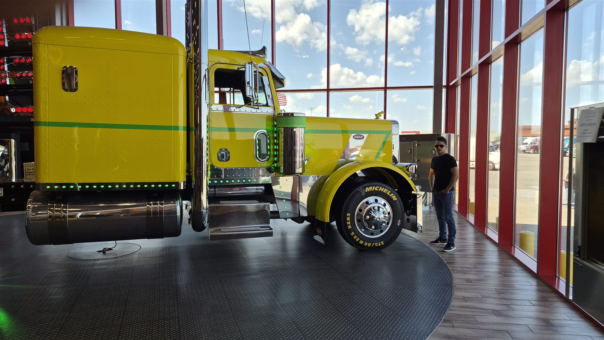 David junto a un camión Peterbilt amarillo